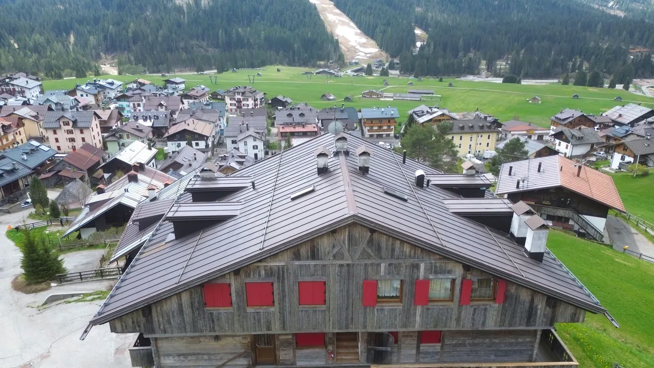 The back of the building from above, with the village, the valley floor and the ski run opposite