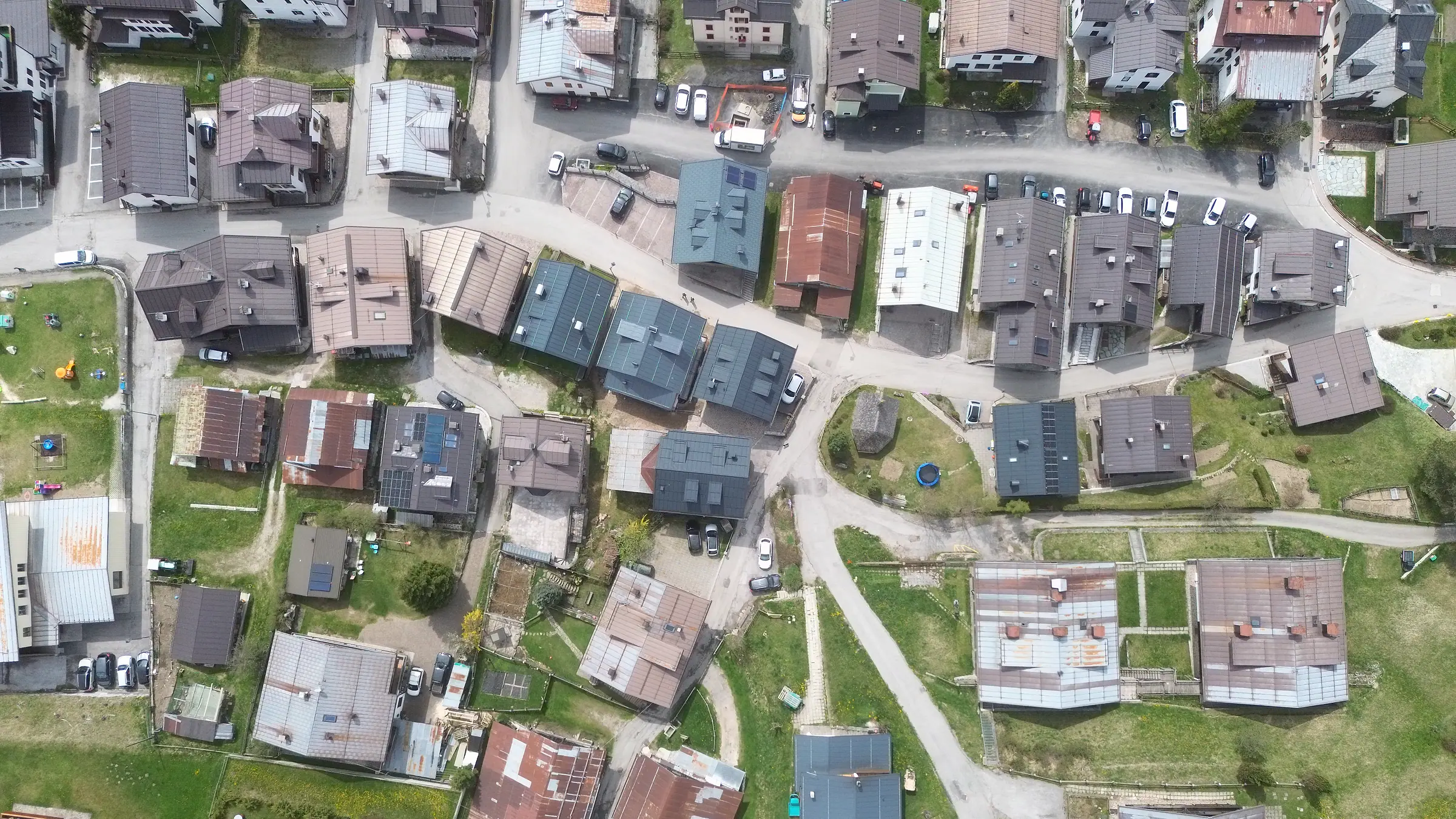 Das Zentrum der Borgata Bach senkrecht von oben: die Hauptstraße mit parkenden Autos und die in parallelen Reihen angeordneten Häuser.