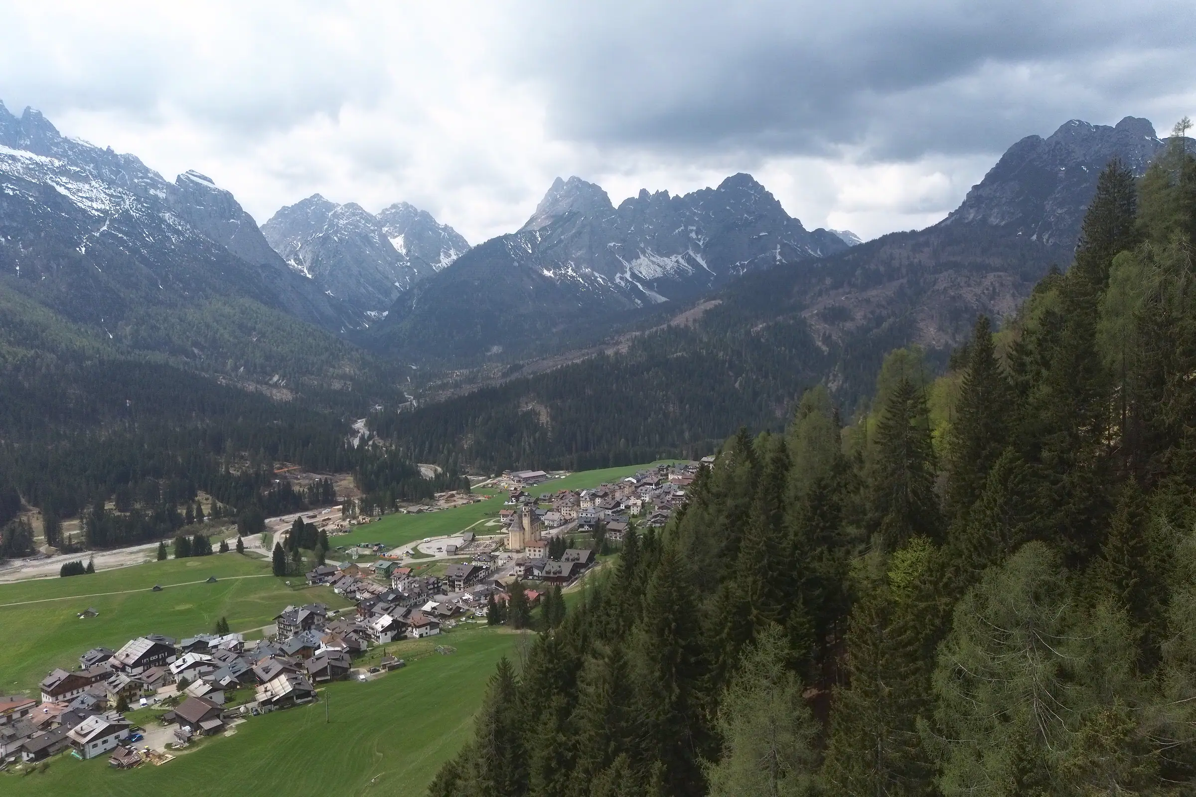 Das Tal nach Westen: vorne die Häuser von Pill, in der Mitte Granvilla mit dem Glockenturm der Pfarrkirche, im Hintergrund die Grate der Terze unter Wolken.
